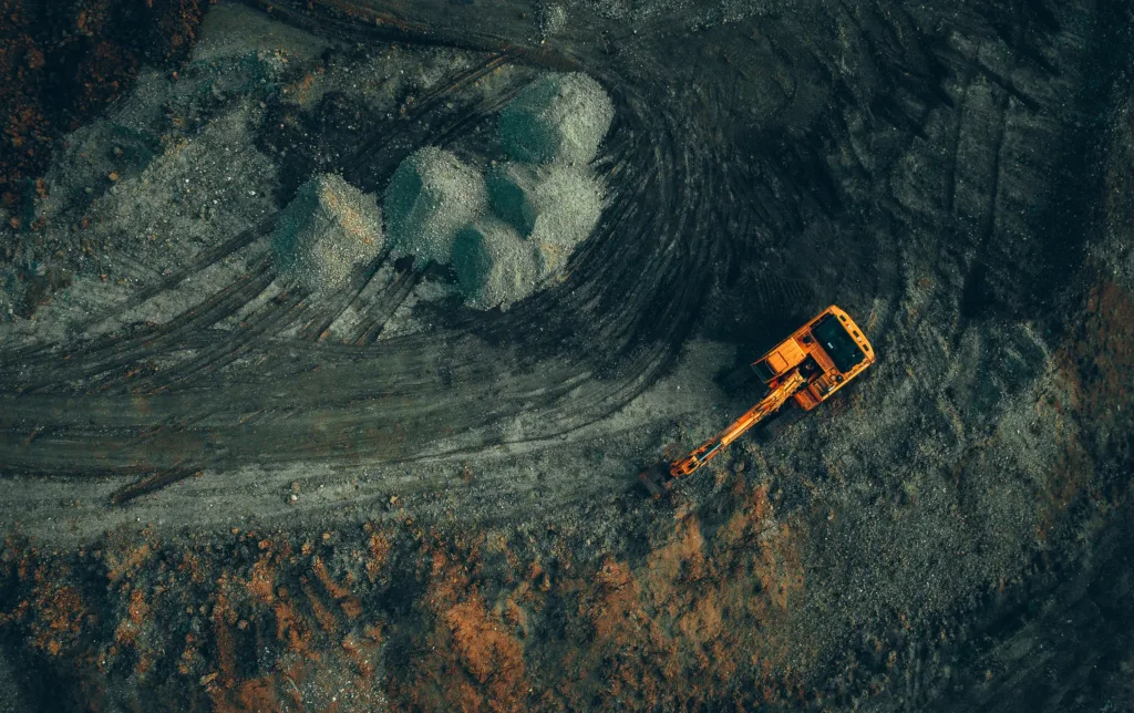 Bright Excavator At Work On A Dark Background View From A Drone