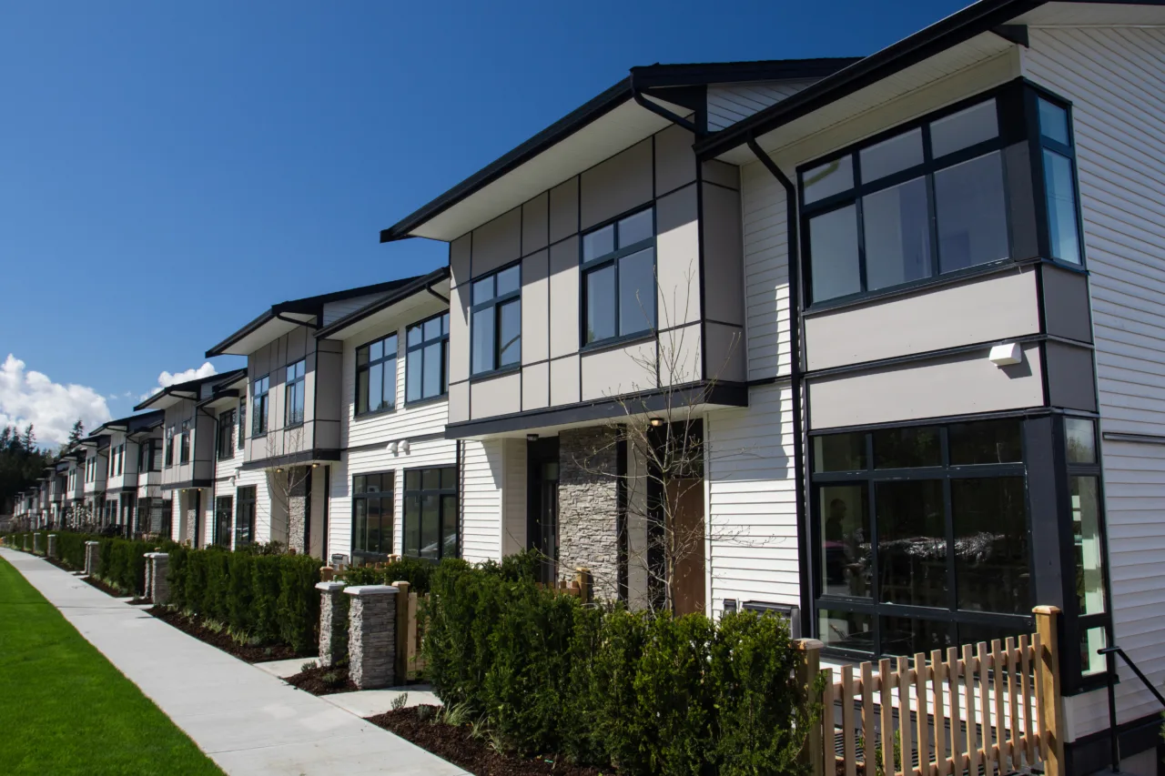 Residential Townhouses On Blue Sky Background On Sunny Day. External Facade Of A Row Of Colorful Modern Urban Townhouses.brand New Houses Just After Construction On Real Estate Market